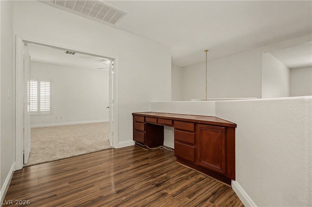 1424 Clipperton Avenue, Henderson, NV 89074 Rich wood-look flooring and custom built-ins define this versatile loft workspace.