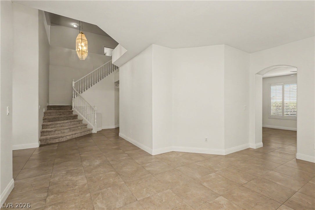 1424 Clipperton Avenue, Henderson, NV 89074 Arched doorways and tile flooring define this welcoming entrance foyer with a classic staircase.