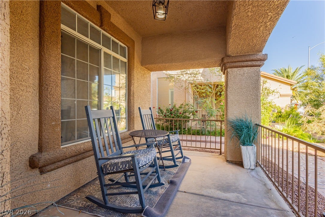 1424 Clipperton Avenue, Henderson, NV 89074 Concrete pillars frame a welcoming front porch set against textured stucco walls and multi-pane windows.
