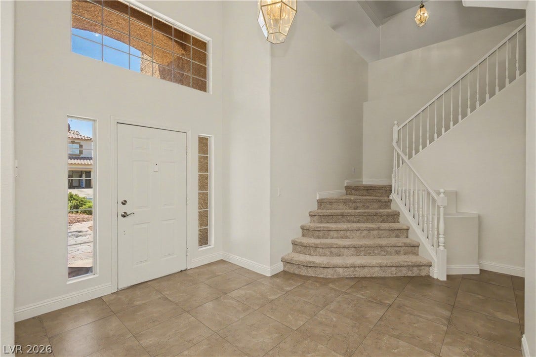 1424 Clipperton Avenue, Henderson, NV 89074 High ceilings and a curved staircase create a welcoming entrance foyer with tile flooring.