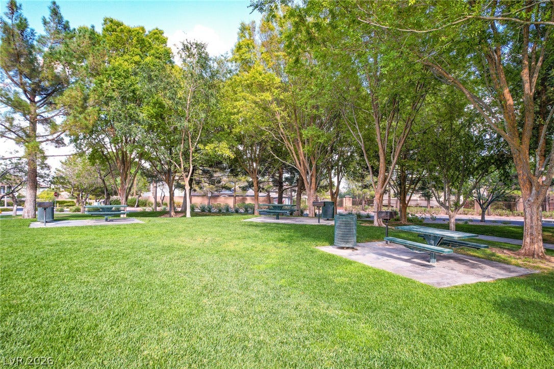 Mature trees shade picnic tables and barbecue areas set upon manicured green lawns.