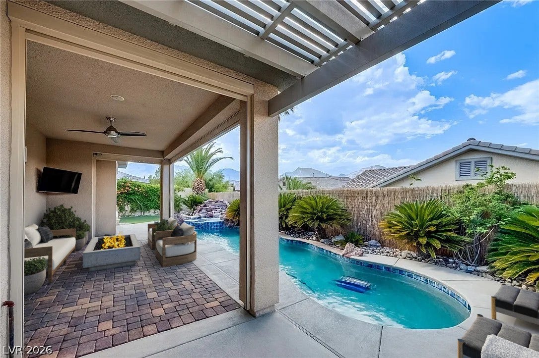 A shaded patio transitions seamlessly to a private pool surrounded by tropical landscaping.