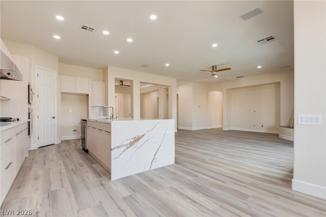 An open floorplan seamlessly connects the modern kitchen and airy living space.