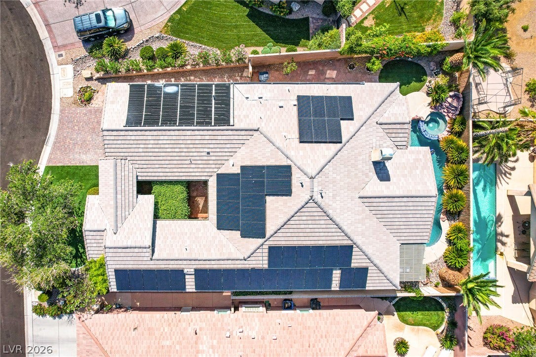 Solar panels line the concrete tile roof of this beautifully landscaped property.