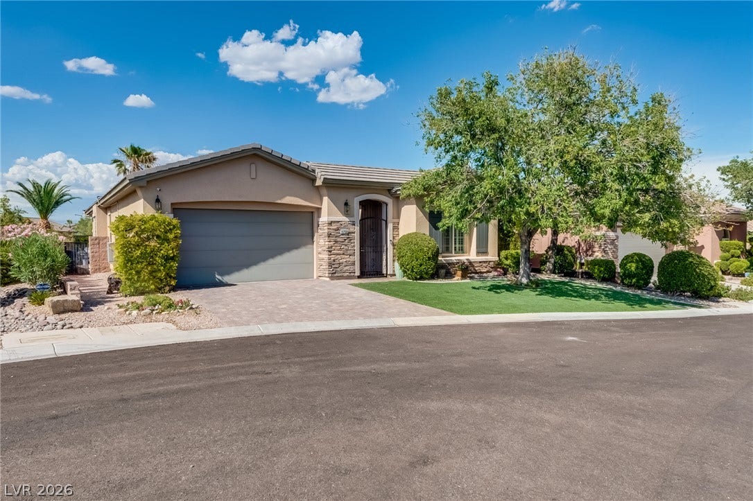 Manicured landscaping and stone accents frame this single-story home with an attached two-car garage.