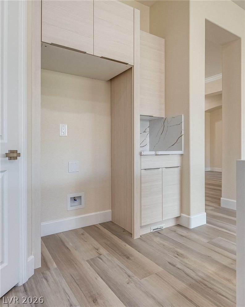 Streamlined built-in cabinetry and stone surfaces elevate this dedicated storage niche.