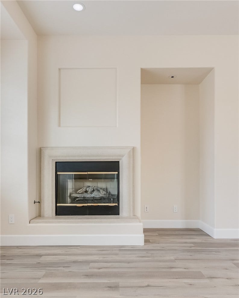An elegant fireplace anchors the room, flanked by an architectural alcove and sleek modern flooring.