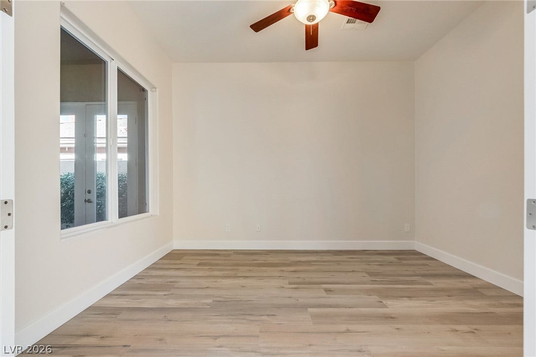 Smooth wood-look flooring and a large window define this versatile interior space.