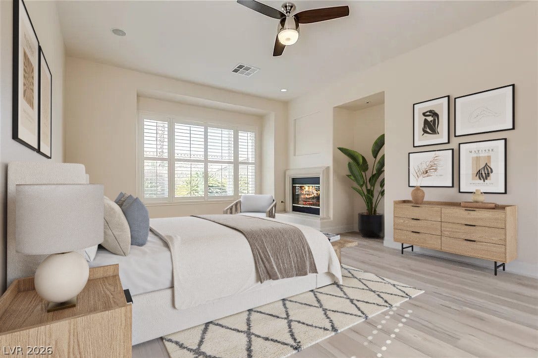 Plank flooring and a cozy fireplace create a relaxing atmosphere in this primary bedroom.