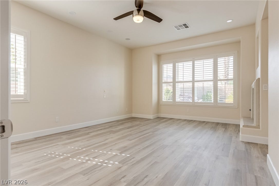 Elegant wood-look flooring and custom shutters elevate this versatile living space.