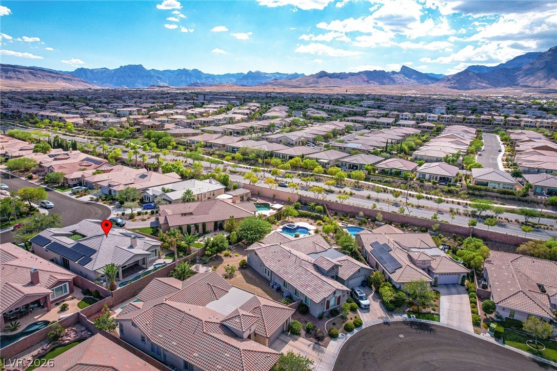 Expansive desert valley views stretch toward a rugged mountain backdrop beyond the surrounding neighborhood.