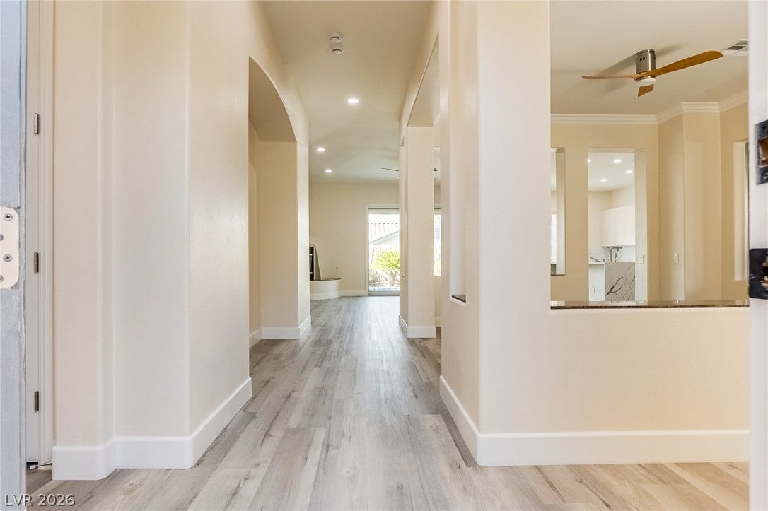 A welcoming entry hall showcases clean architectural lines, durable plank flooring, and recessed lighting.