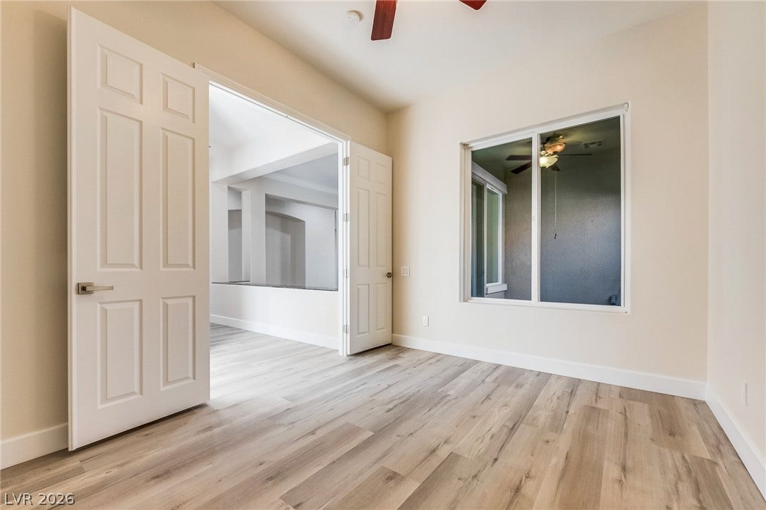 Double doors open to a versatile bonus space featuring smooth wood-plank flooring.