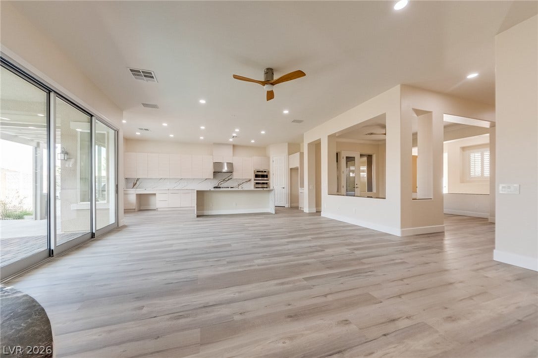 Hardwood floors and expansive glass doors anchor this airy, open-concept layout.