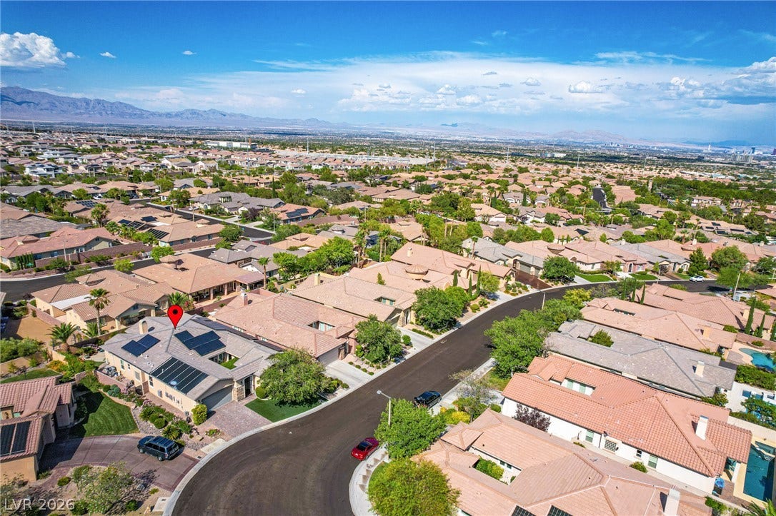 Expansive neighborhood vistas and distant mountain horizons frame this quiet suburban streetscape.