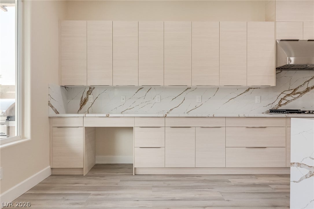 Minimalist flat-panel cabinetry paired with premium stone countertops creates a sleek, functional kitchen design.