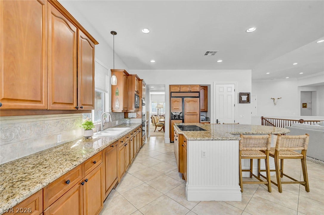 1116 Golden Age Court, Las Vegas, NV 89144 Rich wood cabinetry and expansive granite countertops define this classic, open culinary space.