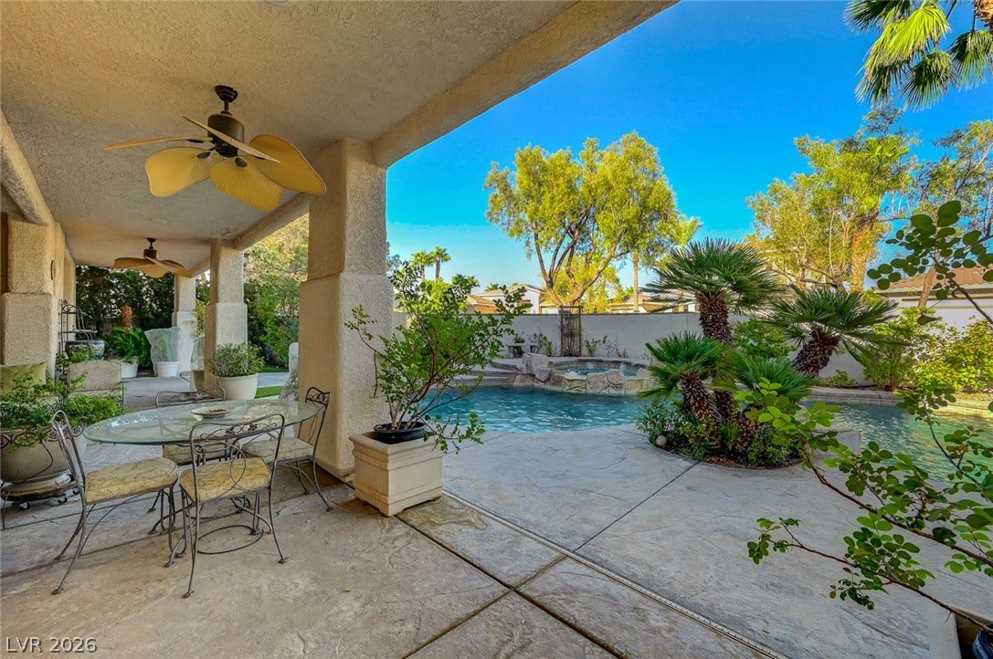 1116 Golden Age Court, Las Vegas, NV 89144 A sheltered concrete terrace looks out onto a sparkling pool and lush landscaping.