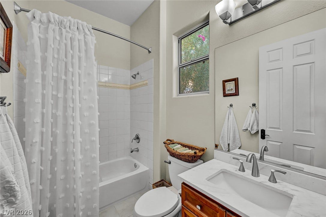 1116 Golden Age Court, Las Vegas, NV 89144 High ceilings and a stone counter vanity define this secondary bath layout.