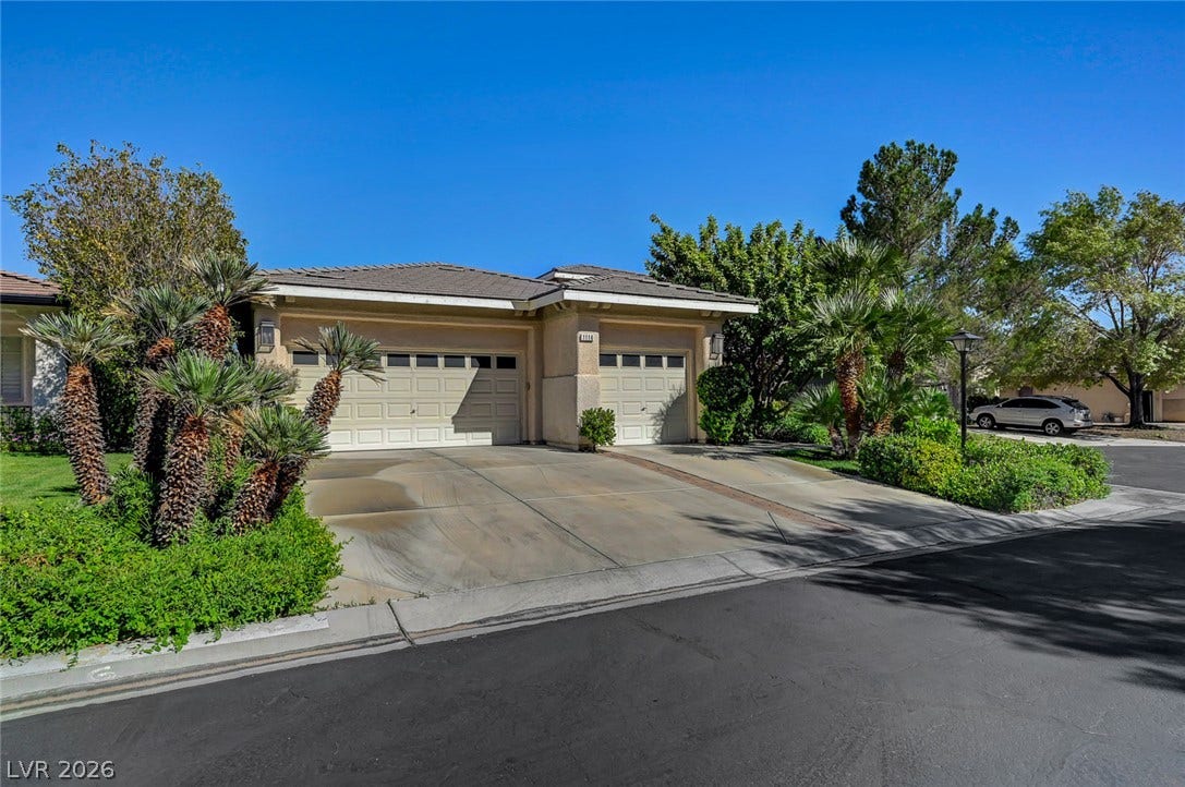 1116 Golden Age Court, Las Vegas, NV 89144 Mature palms and a concrete driveway frame the entrance to this multi-car garage.