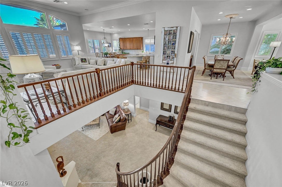 1116 Golden Age Court, Las Vegas, NV 89144 An open multi-level floorplan highlights architectural depth with a curved staircase and high ceilings.