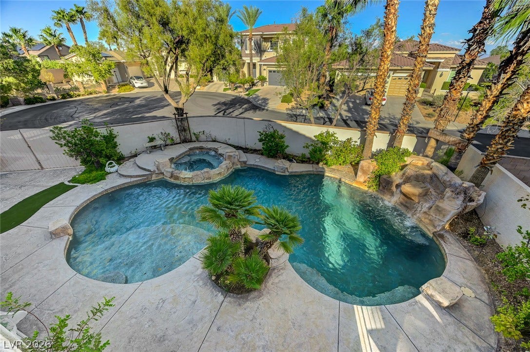 1116 Golden Age Court, Las Vegas, NV 89144 A private backyard oasis features a freeform swimming pool and an integrated elevated spa.