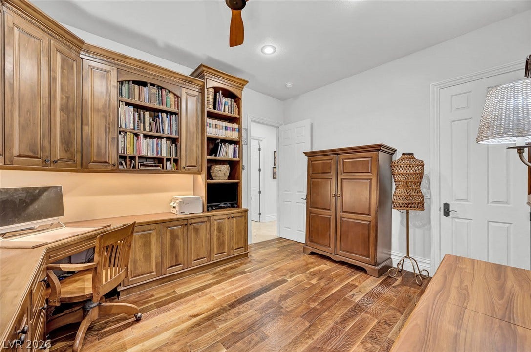 1116 Golden Age Court, Las Vegas, NV 89144 Custom built-in cabinetry and rich hardwood flooring define this functional home office workspace.