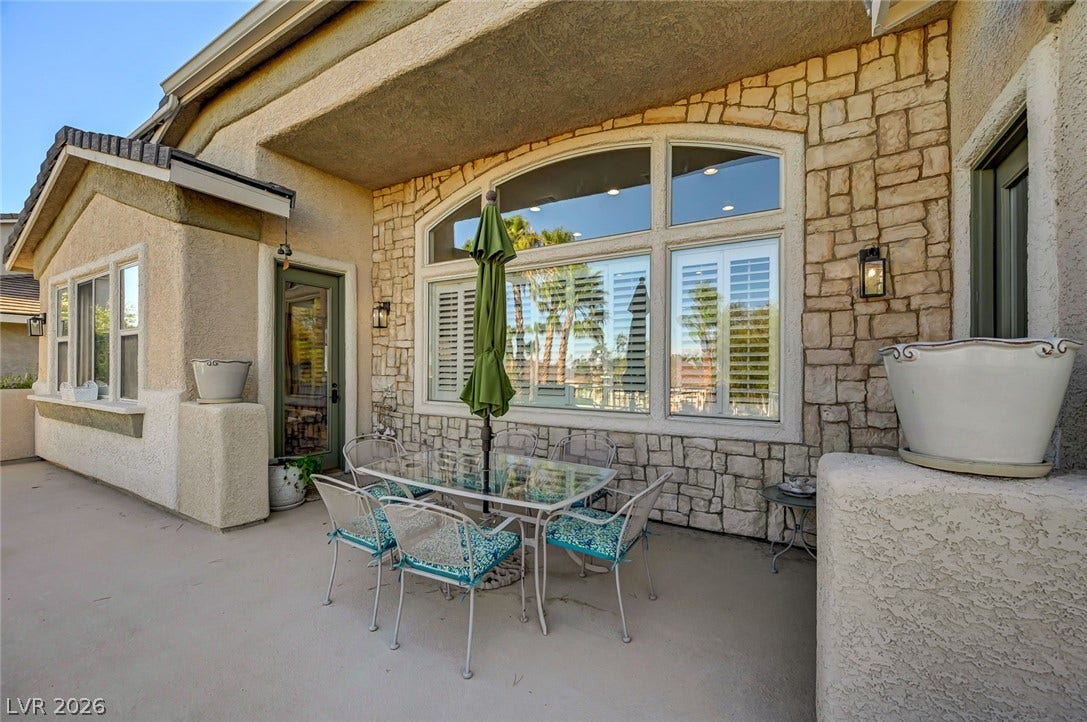 1116 Golden Age Court, Las Vegas, NV 89144 Textured stone accents and large arched windows frame this inviting outdoor patio area.