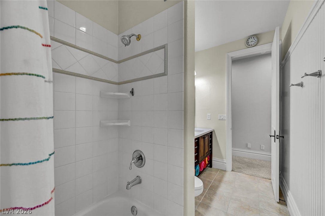 1116 Golden Age Court, Las Vegas, NV 89144 Tiled tub surround integrates seamlessly with the neutral flooring of this functional bathroom.