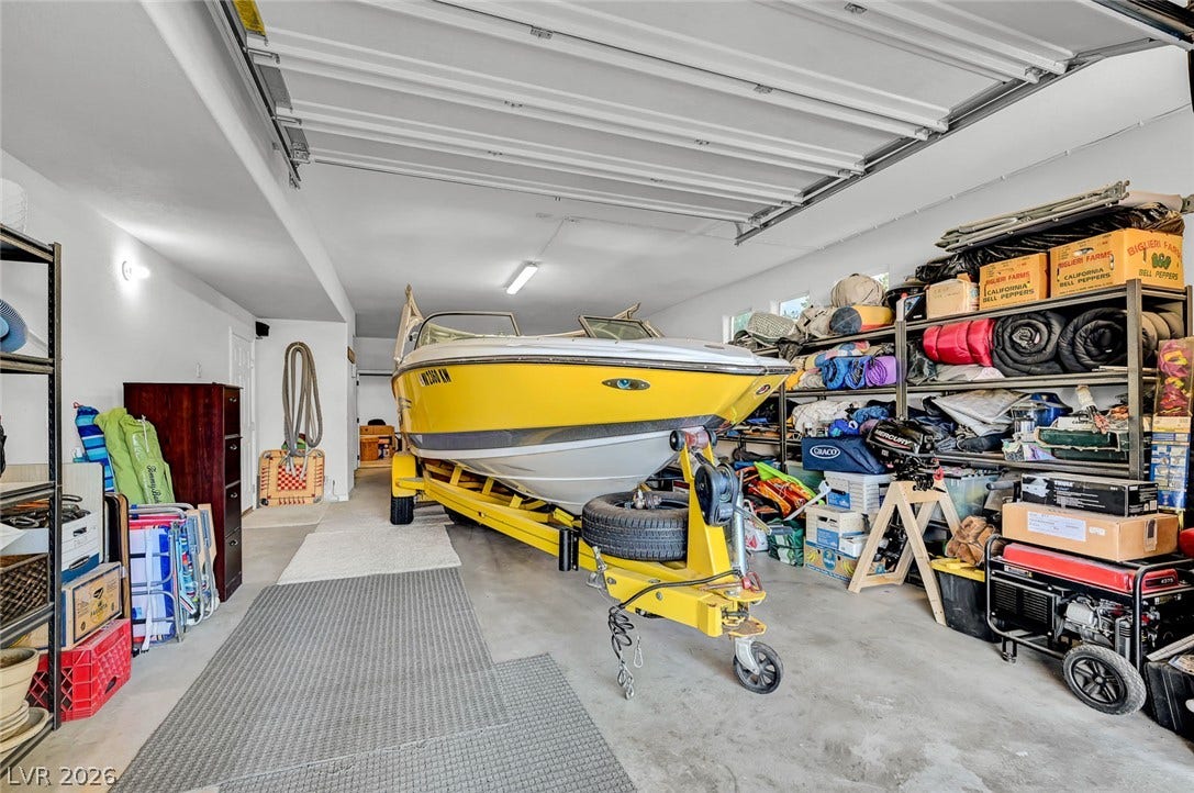 1116 Golden Age Court, Las Vegas, NV 89144 An oversized two- car garage with durable concrete flooring offers abundant space for vehicles and recreational storage, complemented by a custom-designed storage area for added organization and convenience.