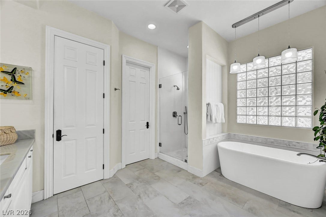 1116 Golden Age Court, Las Vegas, NV 89144 A freestanding tub rests beside a glass block window in this modern bathroom.