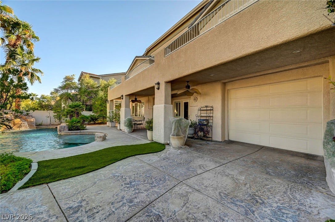 1116 Golden Age Court, Las Vegas, NV 89144 Stamped concrete decking frames a serene pool area situated alongside the stucco exterior.