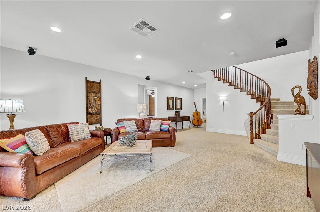 1116 Golden Age Court, Las Vegas, NV 89144 A curved staircase with wooden banisters ascends from this expansive carpeted living space.