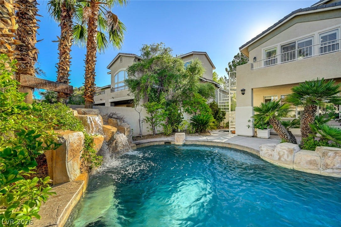 1116 Golden Age Court, Las Vegas, NV 89144 Lush tropical landscaping surrounds a sparkling backyard swimming pool complete with a stone waterfall feature.