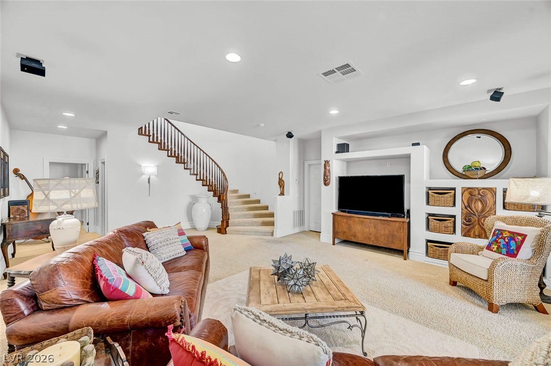 1116 Golden Age Court, Las Vegas, NV 89144 An elegant curved staircase anchors this expansive living area featuring recessed lighting and integrated media built-ins.