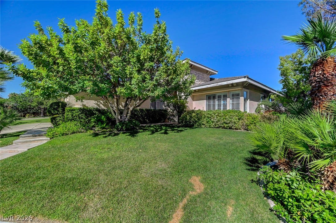 1116 Golden Age Court, Las Vegas, NV 89144 Lush manicured turf and mature trees frame this elegant exterior under clear blue skies.