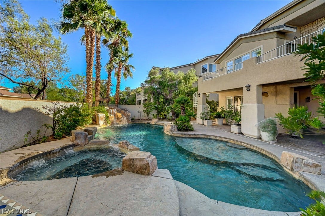 1116 Golden Age Court, Las Vegas, NV 89144 Palm trees and rock formations frame a custom swimming pool with an integrated spa.