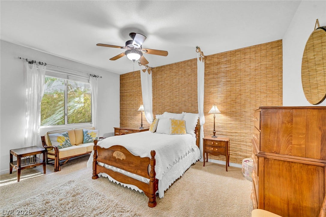 1116 Golden Age Court, Las Vegas, NV 89144 A spacious bedroom features neutral carpeting and a wide window overlooking the greenery.