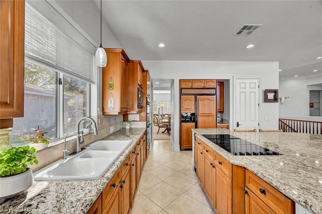 1116 Golden Age Court, Las Vegas, NV 89144 Polished granite countertops and classic wood cabinetry define this functional kitchen space.