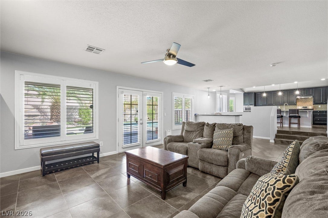 1584 Bozeman Drive, Henderson, NV 89012 Gleaming tile floors and double French doors define this airy open-concept living space.
