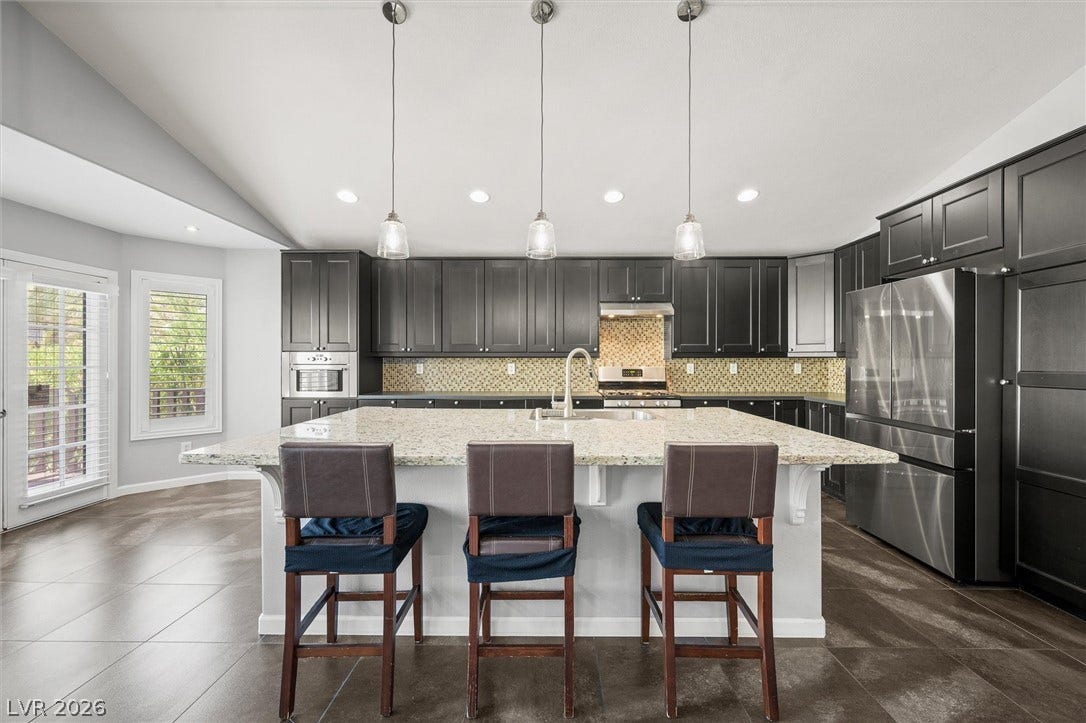 1584 Bozeman Drive, Henderson, NV 89012 Granite countertops and dark cabinetry create a handsome look in this open kitchen.