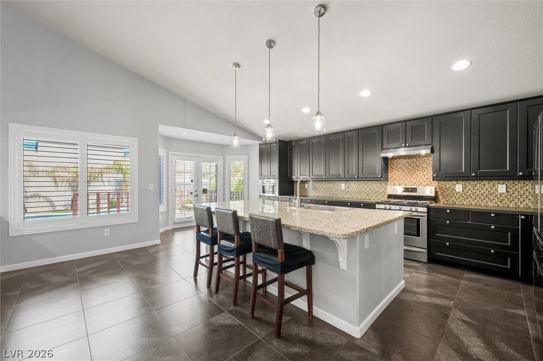 1584 Bozeman Drive, Henderson, NV 89012 Rich dark cabinetry and a spacious central island define this modern culinary space.