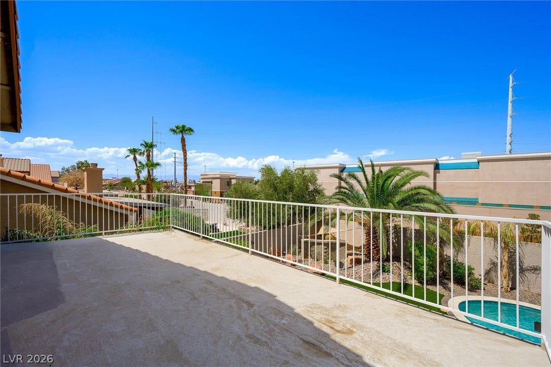 1584 Bozeman Drive, Henderson, NV 89012 An elevated terrace overlooks palm trees and the backyard swimming pool under clear blue skies.