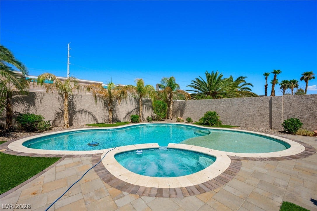 1584 Bozeman Drive, Henderson, NV 89012 An inviting backyard oasis showcases a pristine swimming pool and integrated spa bordered by stone pavers.