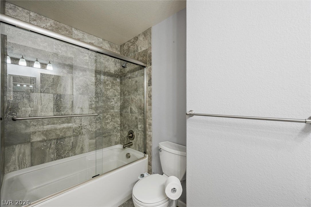 1584 Bozeman Drive, Henderson, NV 89012 Floor-to-ceiling tilework and sleek glass doors elevate this modern bath design.