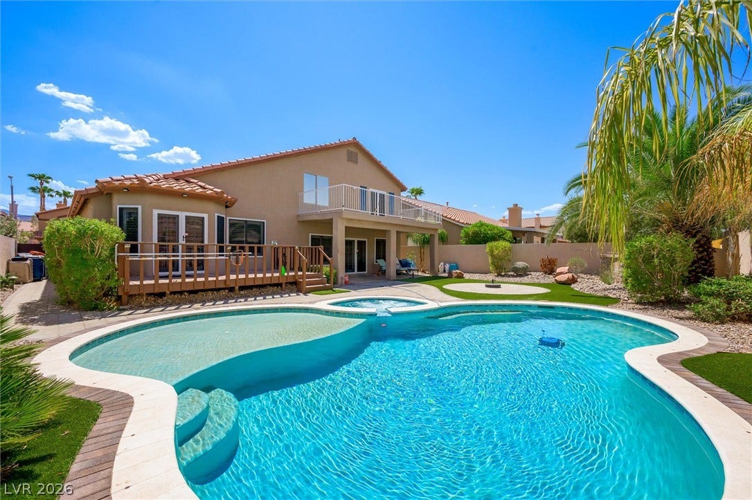 1584 Bozeman Drive, Henderson, NV 89012 An inviting backyard oasis features a shimmering pool, elevated wood deck, and private stucco exterior.