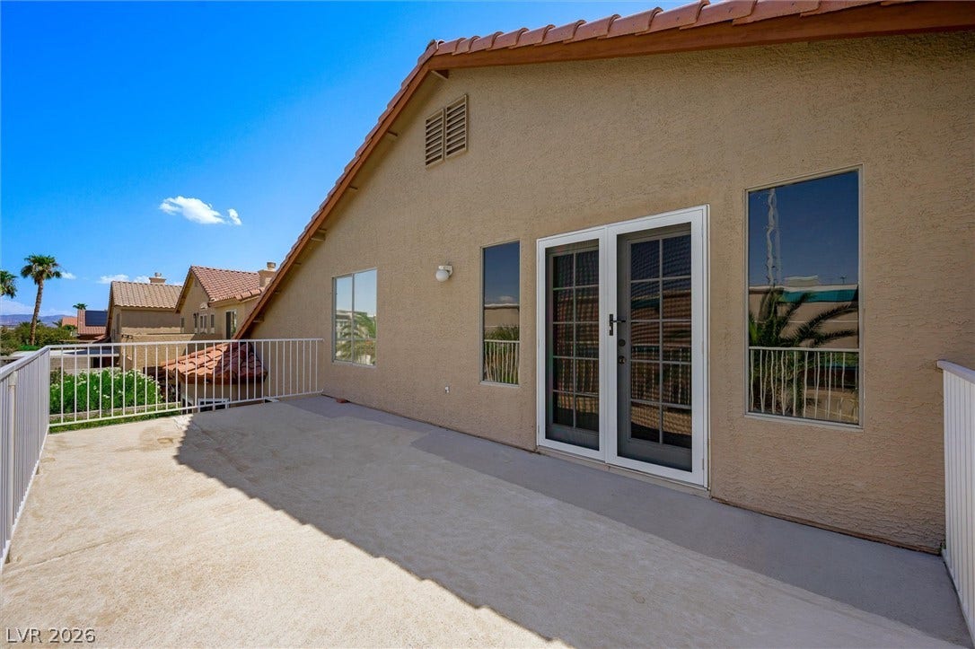 1584 Bozeman Drive, Henderson, NV 89012 An elevated concrete balcony features metal railings, stucco walls, and glass doors.