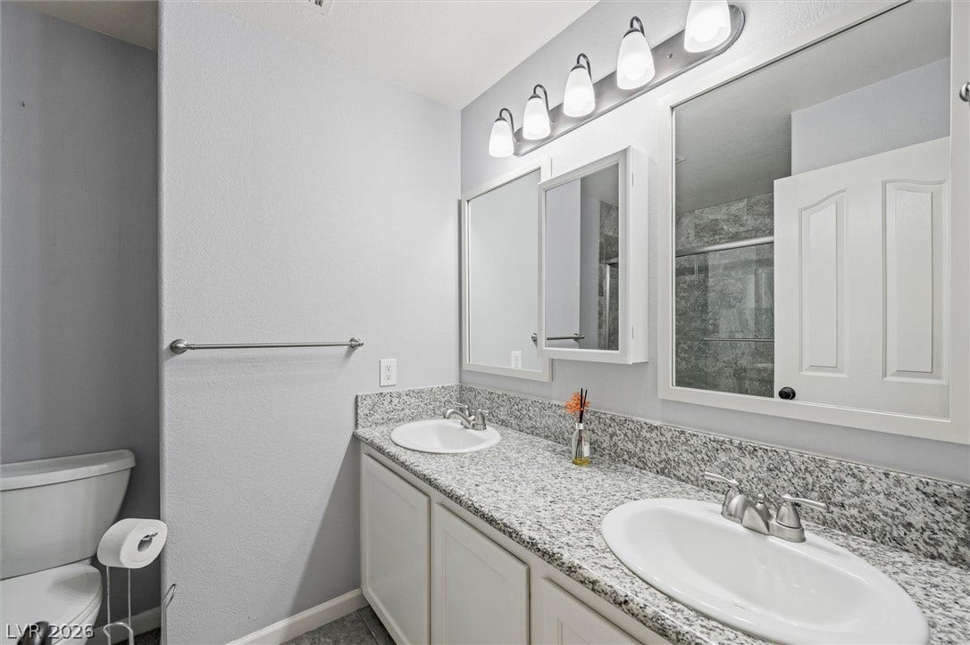 1584 Bozeman Drive, Henderson, NV 89012 Granite counters and dual sinks elevate this modern bathroom layout.