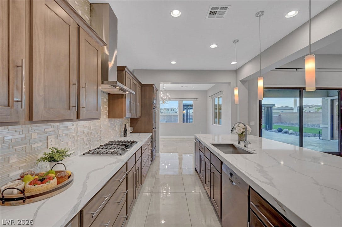 Polished tile flooring and premium stone countertops define this modern, open-concept culinary space.