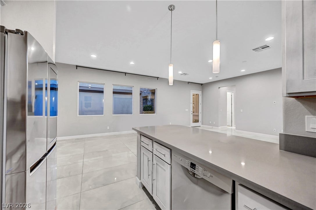 Polished tile floors and soaring ceilings create an airy, modern atmosphere in this open space.